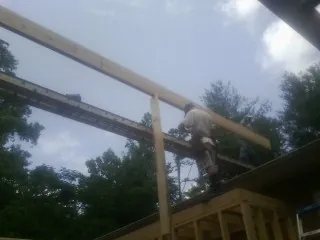 Carpenter setting a ridge beam over a new addition frame — Ice Dam Removal by Roofing Brothers in La Follette