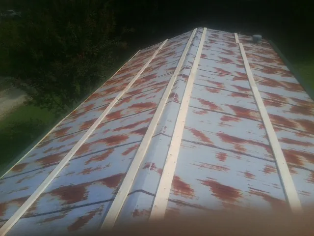Rusted metal roof panels with new wood purlins before replacement — Storm Damage Roof Repair in La Follette by Roofing Brothers