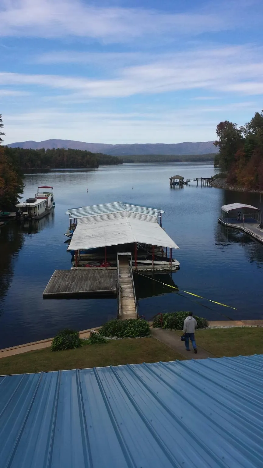 View across a lake from a newly installed blue metal roof in La Follette
