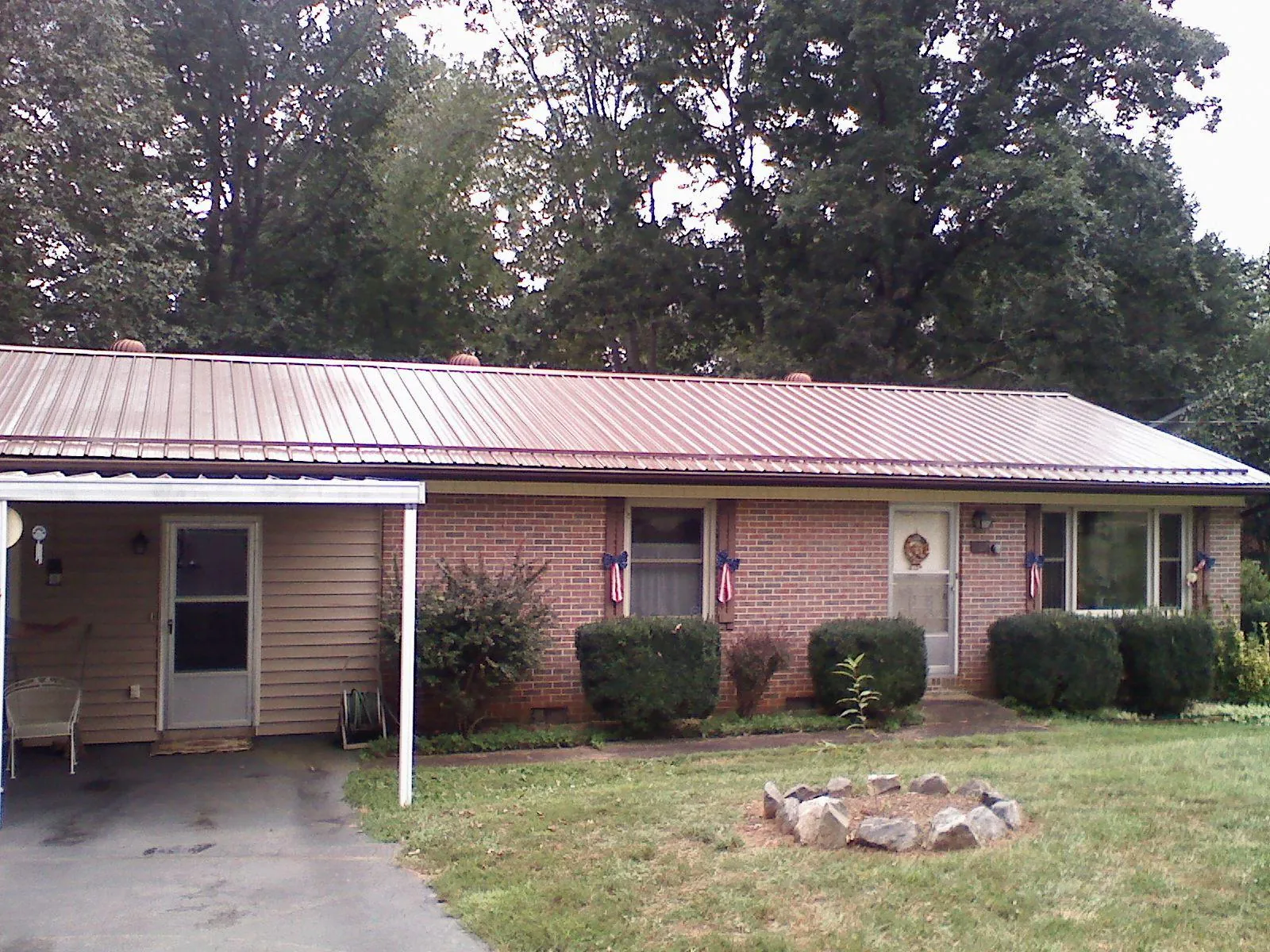 Bronze metal roof and carport on a brick ranch home — Roof Repair work by our crew in La Follette
